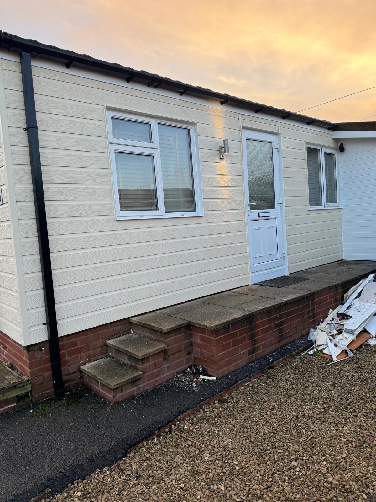 Park home with beautiful new cladding at sunset